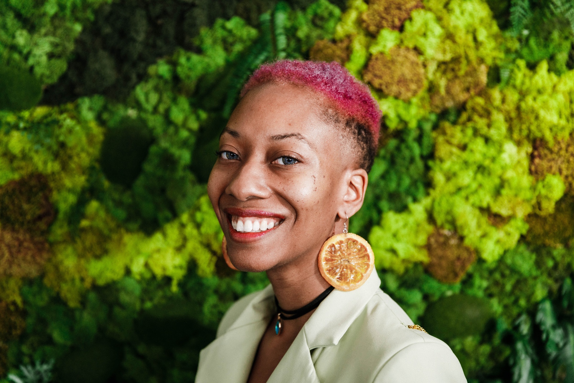 Crystal Pope, visibility strategist, smiling in front of a moss wall